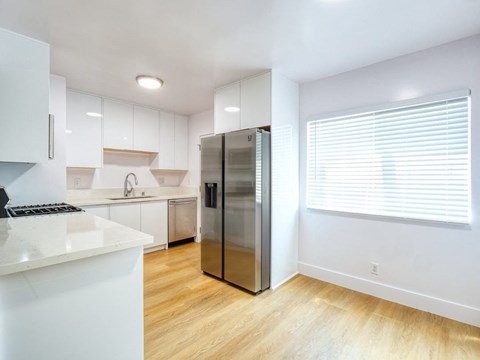 a kitchen with white cabinets and a stainless steel refrigerator